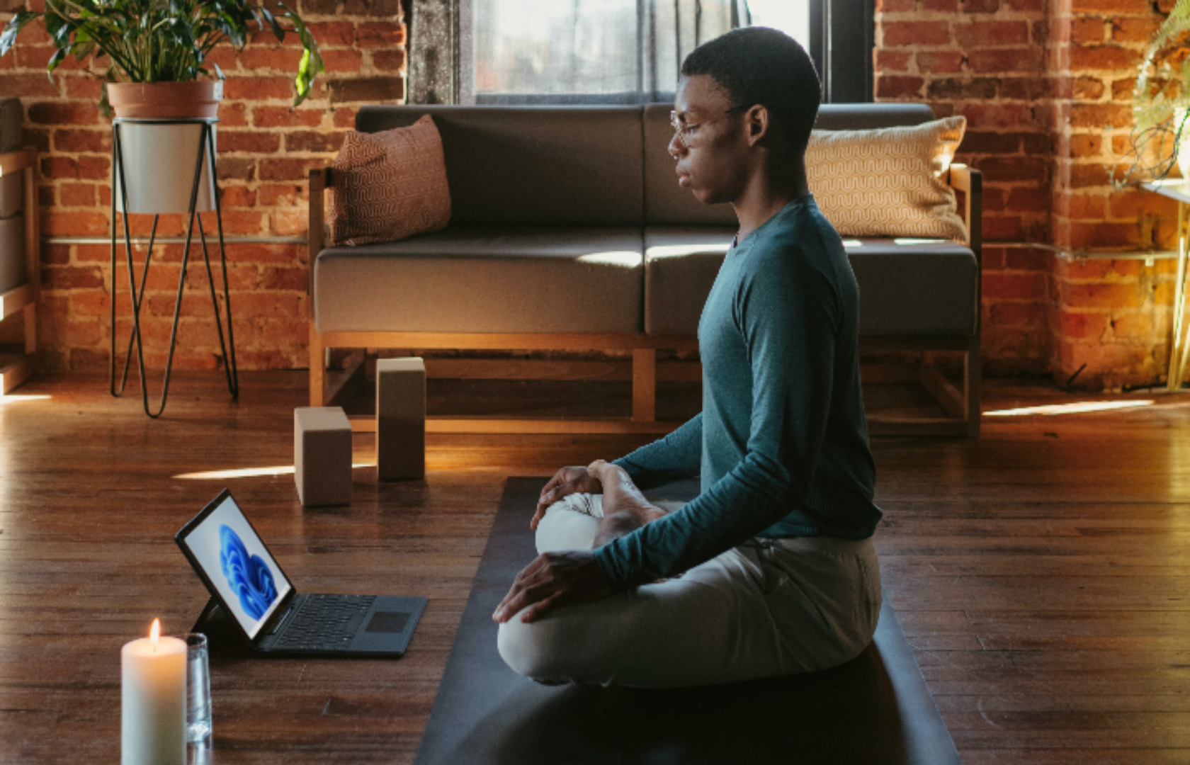 Black person meditating cross-legged in a room